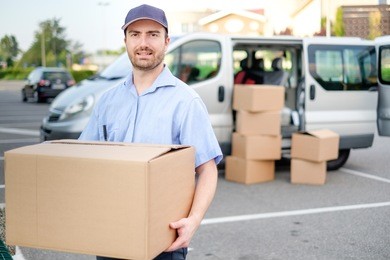 portrait of confidence express courier next to his delivery van