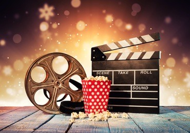 retro film production accessories placed on wooden planks. concept of film-making. blur spot lights on background