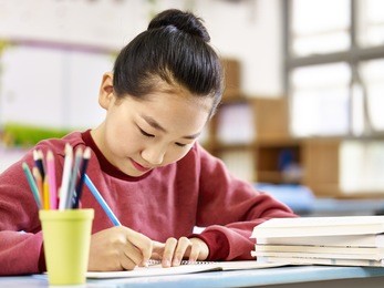asian primary school student studying or doing homework in classroom.