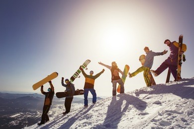 group of people snowboarders and skiers on mountain sunset. winter sport outdoor