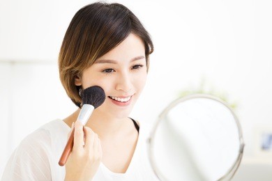  young woman doing  makeup in front of the mirror