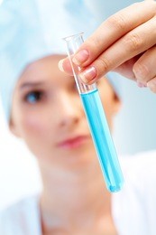 close-up of glass tube with blue fluid in nurse hand during medical test