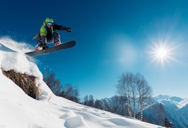 snowboarder is jumping with snowboard from snowhill