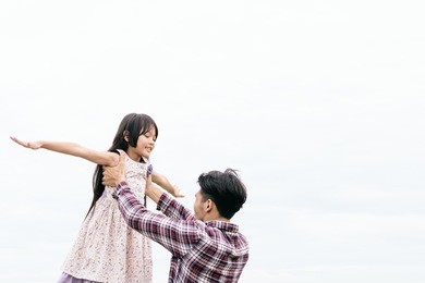 happy family together, father raising daughter up in the air.