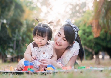 beautiful asian mom and baby playing toy  happiness in the park , outdoor