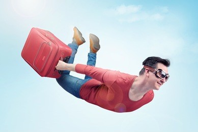 crazy man in goggles and with red suitcase flies in the sky. concept of vacation