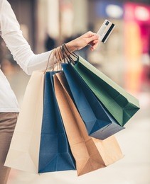 cropped image of beautiful girl with shopping bags and credit card doing shopping in the mall