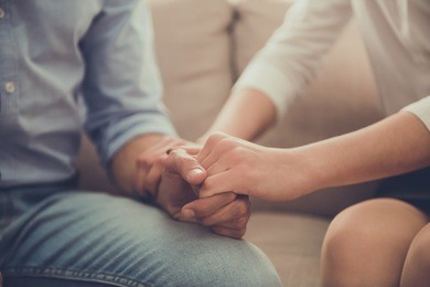 cropped image of beautiful female psychologist holding her client's hands during the seance
