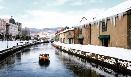 view of otaru canal in winter season with signature tourist boat, hokkaido - japan.
