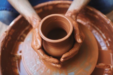 pottery artisan making fireclay jugs in his atelier