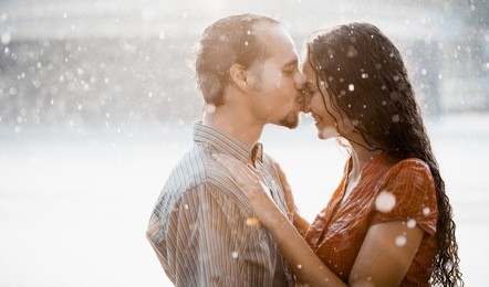 two lovers kissing under summer rain
