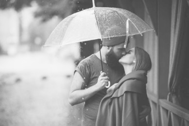 guy and the girl posing together in the rain on a city street