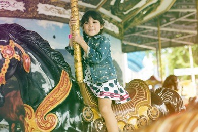 little girl amusement park playful merry go round