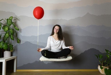 girl levitates on a hot air balloon in the room, flight in a lotus pose
