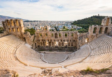 ancient odeon of herodes atticus in athens, greece on acropolis hill with view over the city, sunset light and selective focus