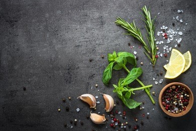 selection of spices herbs and greens. ingredients for cooking. food background on black slate table. top view copy space.