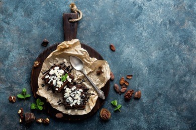 chocolate brownie cake, dessert with nuts on dark background, directly above, copy space
