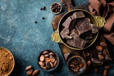 dark chocolate pieces crushed and cocoa beans, culinary background, top view