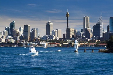 sydney australia cbd close-up with lighthouse and boat in harbour water blue sky skyscrapers