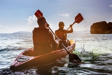 man and woman swims on kayak in the sea on background of island. kayaking concept