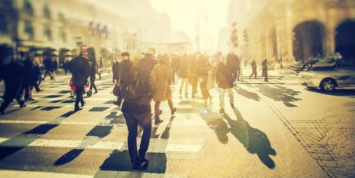 crowd of anonymous people walking on sunset in the city streets
