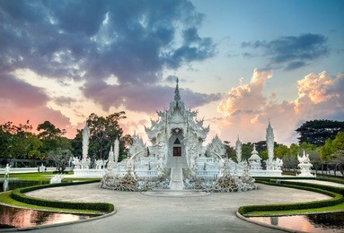 wat rong khun the white temple and pond at dramatic sunset background in chiang rai, thailand