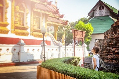 a young woman travel to thailand, visiting the sights. buddhist thai temple in chiang mai