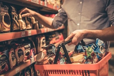 cropped image of handsome man with a market basket doing shopping at the supermarket