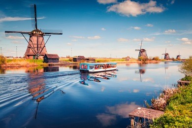 famous windmills in kinderdijk museum in holland. sunny spring morning in countryside. colorful outdoor scene in netherlands, europe. unesco world heritage site. artistic style post processed photo.
