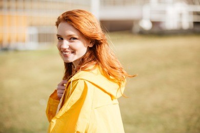 portrait of a friendly pretty ginger hair girl in coat outdoors