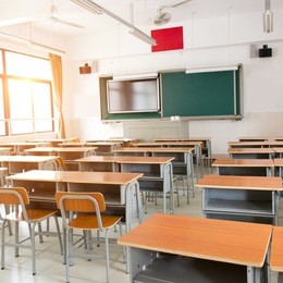 empty classroom with chairs, desks and chalkboard.