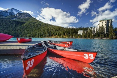 red canoes in the foreground at lake louise with chateau lake louise in the background