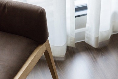 contemporary interior of living room with part of sofa in sunny day and white curtain interior background concept