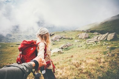 couple travelers man and woman follow holding hands at foggy mountains landscape on background love and travel happy emotions lifestyle concept. young family traveling active adventure vacations