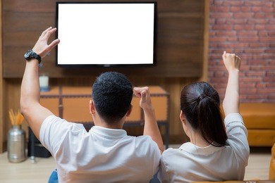 two asian couple see the television on sofa in family room in home, tv and green screen , blue screen concept