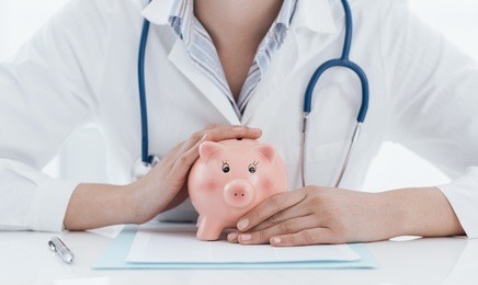 female doctor and piggy bank: health insurance, medical expenses and tax concept