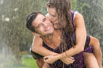 couple in love playing in the summer rain