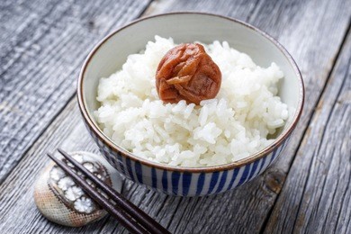traditional japanese koshihikari rice with umeboshi as close-up in a bowl