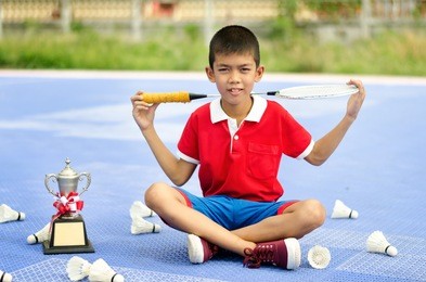 the boys won the badminton tournament. kid holding trophy 