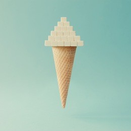 ice cream cone with sugar cubes on bright blue background. minimal food concept.