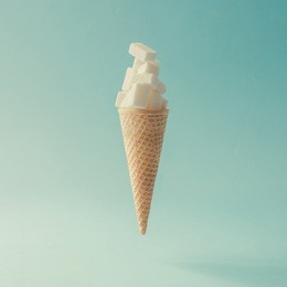 ice cream cone with sugar cubes on bright blue background. minimal food concept.