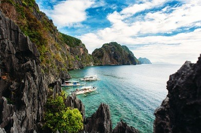 el nido, palawan, philippines. philippine boats in turquoise clean water with sharp rocks a background. tropical country. wide angle, top view
