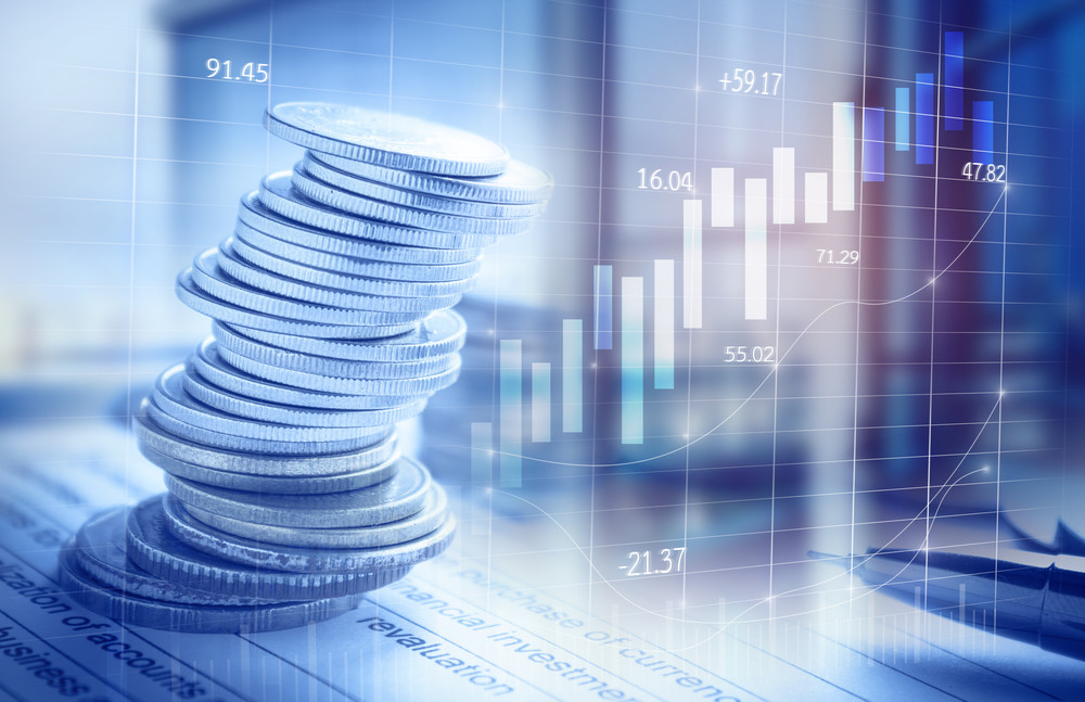 double exposure of city and coin stack on banking account in the background with chart and graph