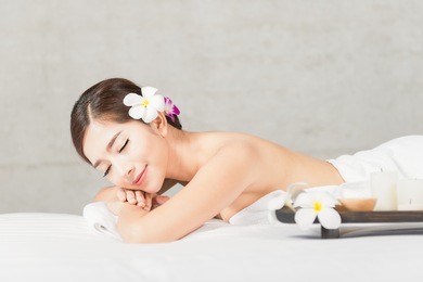 portrait of asian people, beauty, spa, healthy lifestyle and relaxation concept - close up of beautiful young asian woman lying with closed eyes and having hand massage in spa salon