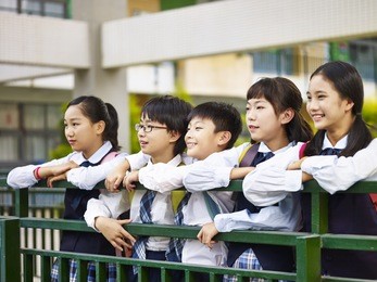 portrait of a group of happy and smiling elementary school students in uniform.