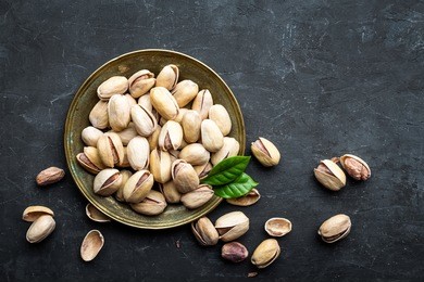 pistachios nuts on dark background, top view, healthy snack