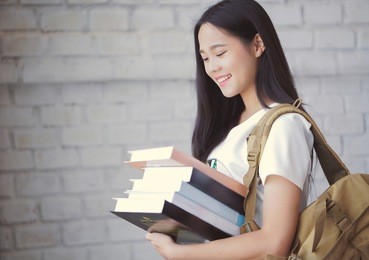 asian students holding books at university