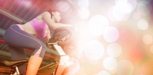 low angle view of a determined young woman working out at spinning class in gym