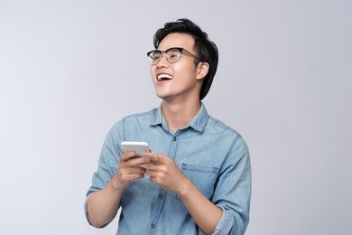 smart casual asian man using smartphone in studio background