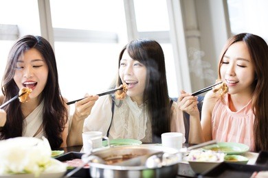 happy young women group  eating hot pot 